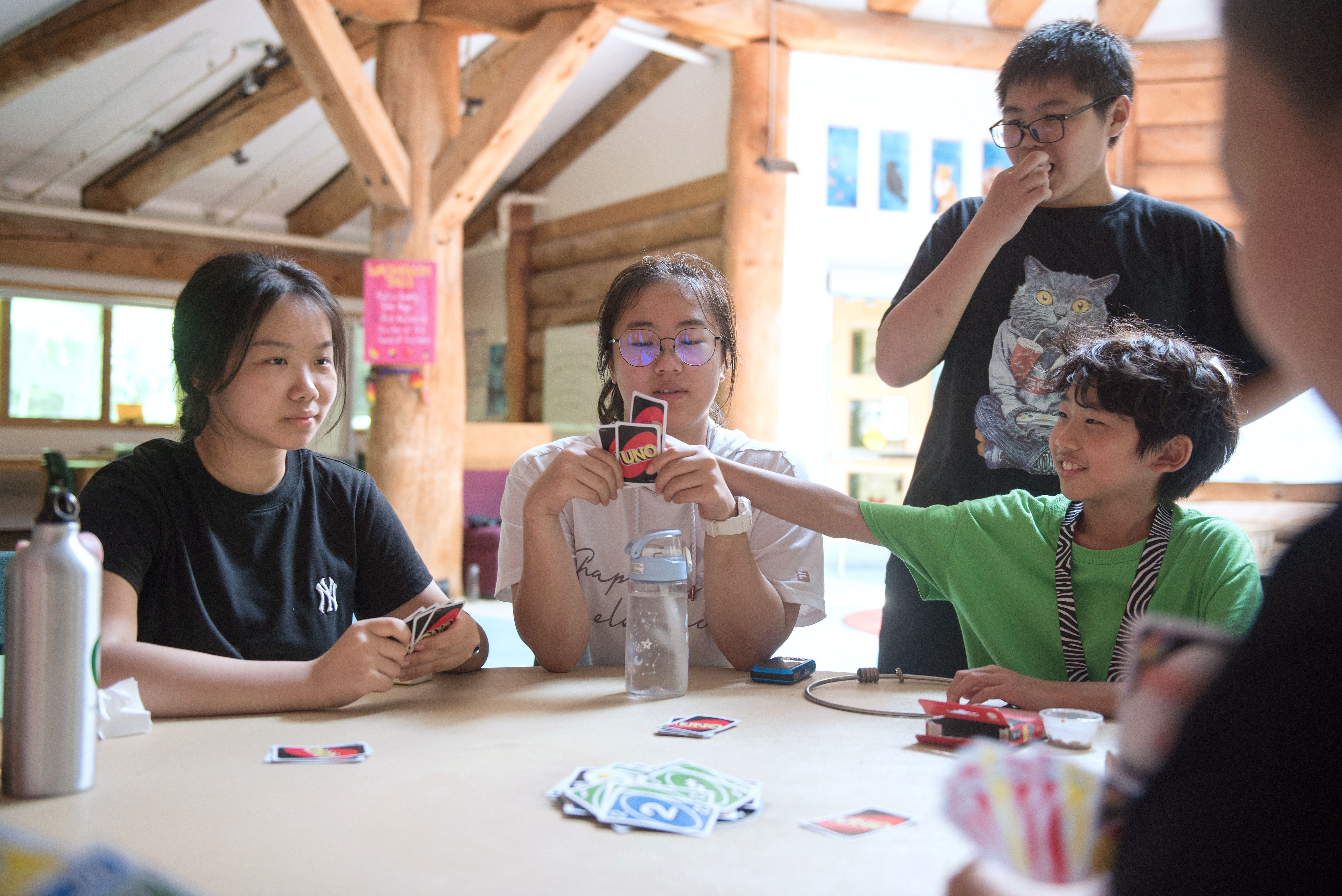 Students sitting at a table playing the card game Uno Open Gallery